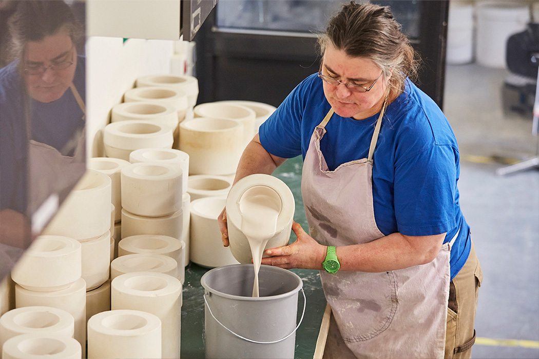 Eine Frau arbeitet mit Grußformen in der Keramik-Manufaktur der Lebenshilfe Stuttgart